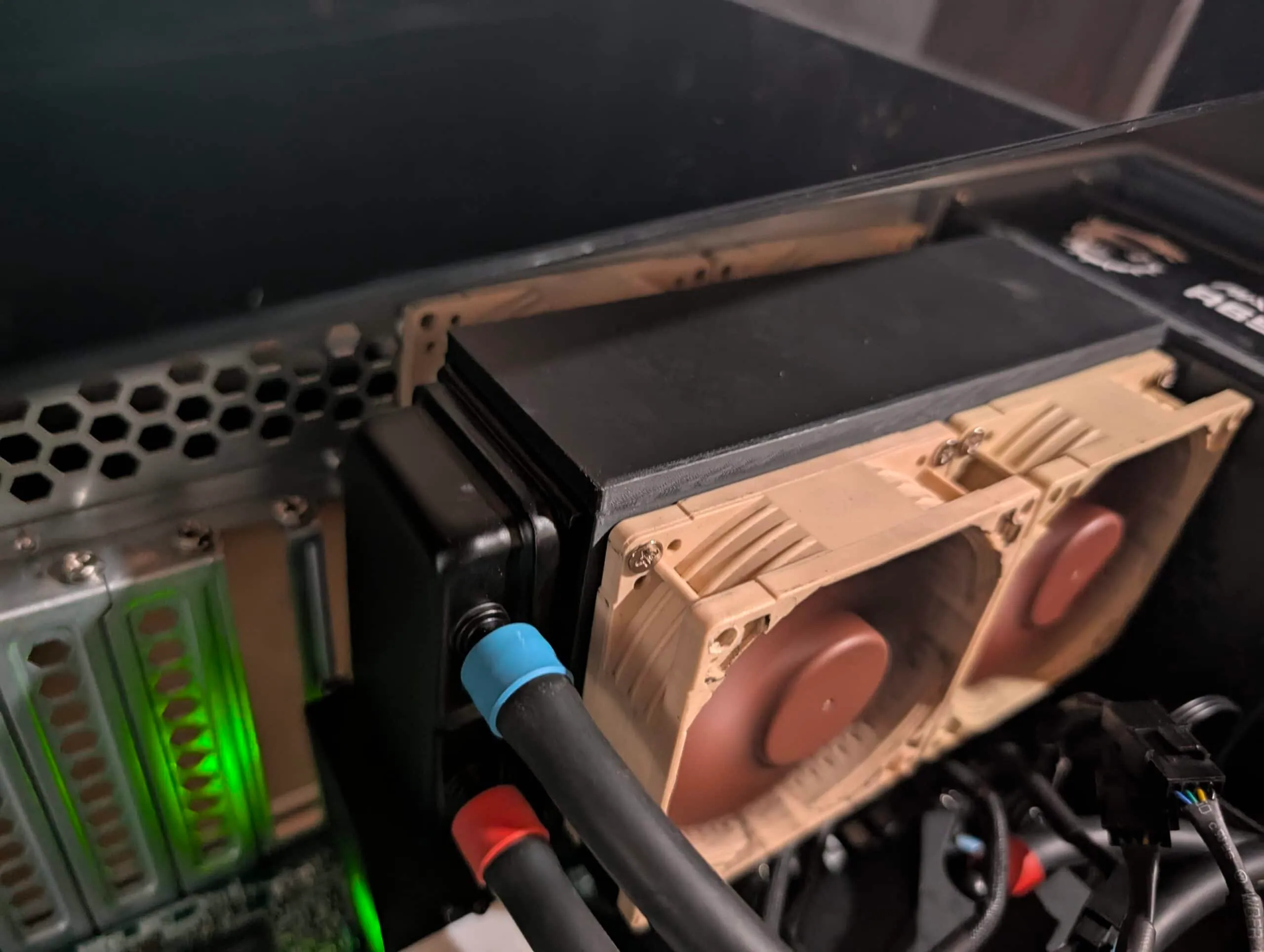 Side view of the AIO radiator in the printed bracket with Noctua fans, coolant hoses in front